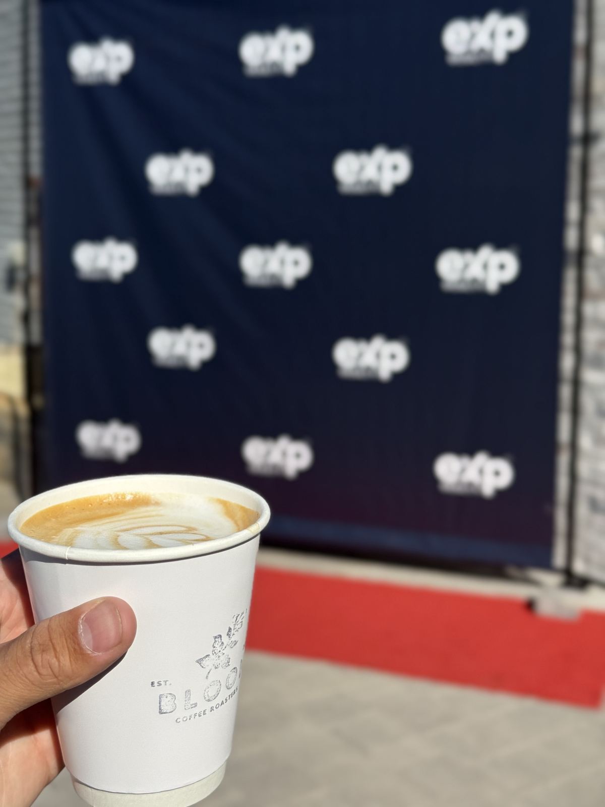 Bloom branded cup at an eXp Realty brand activation