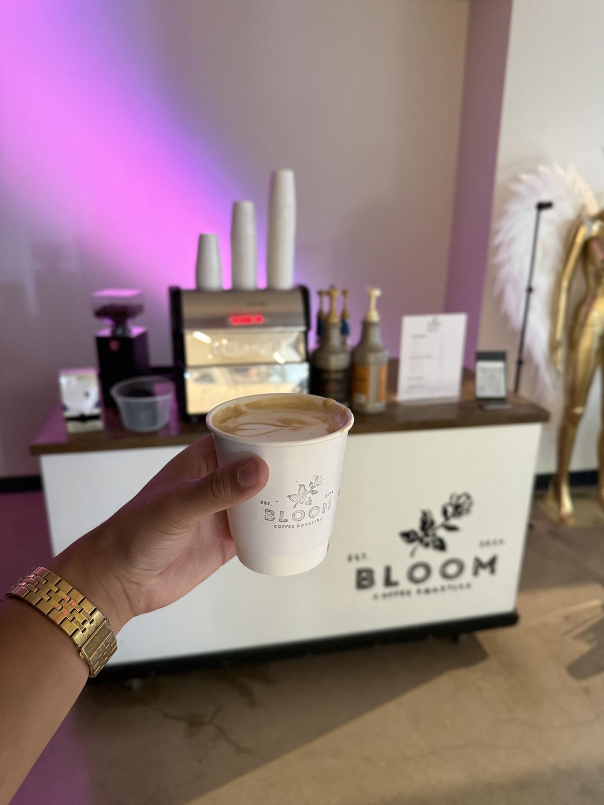 Branded Bloom coffee cart with event lighting at a brand activation
