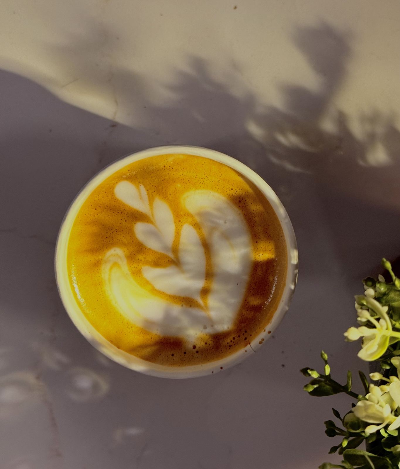 Latte art from above with flower shadows at a wedding